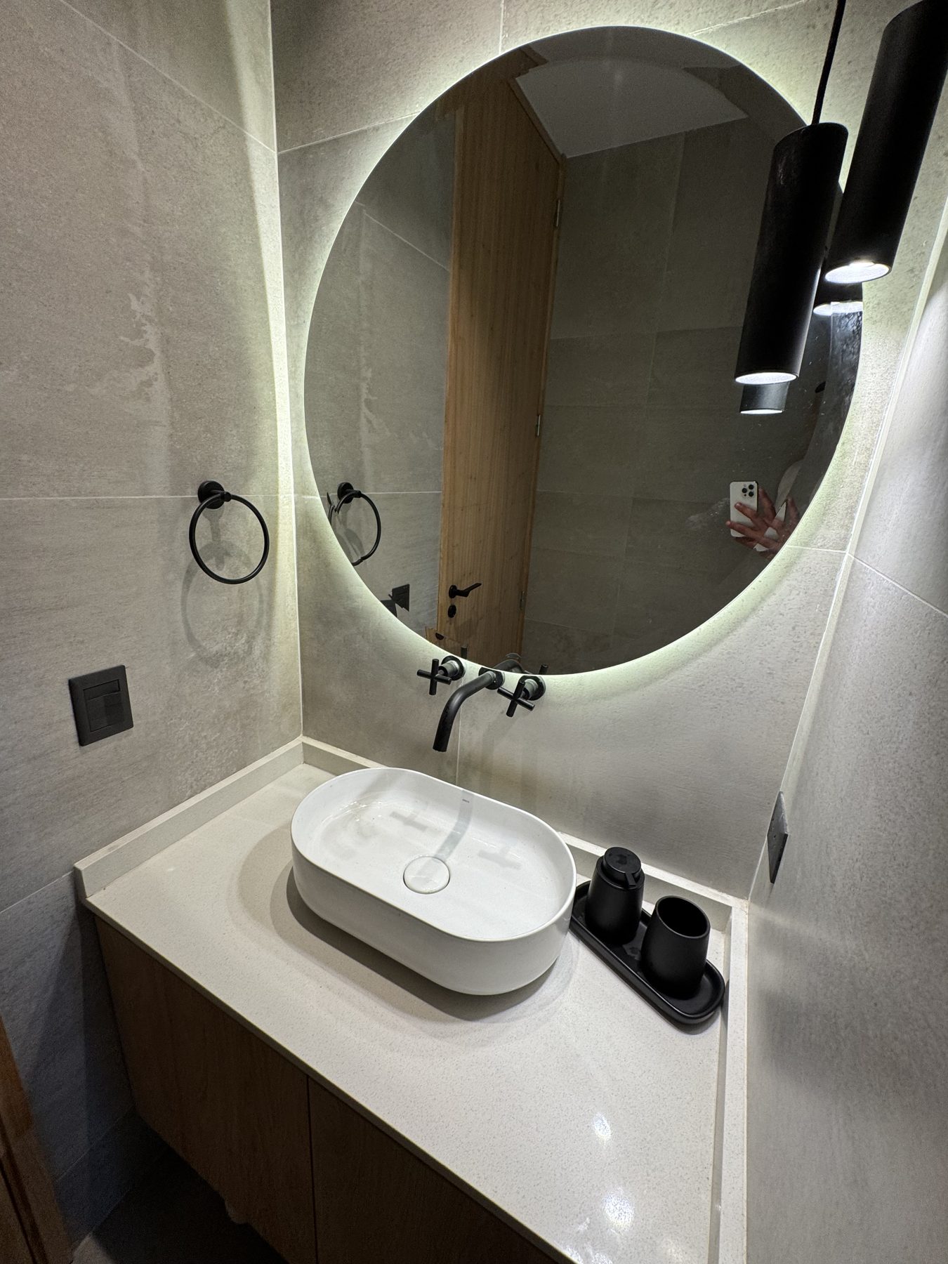 Baño con espejo circular iluminado
